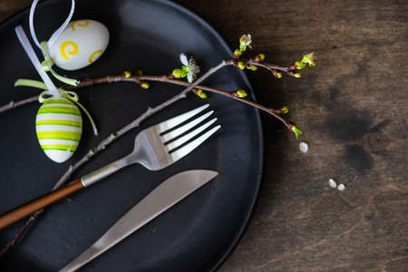Feastive table setting for holiday Easter dinner decorated with blooming cherry  flowers on rustic table with copy spaceの写真素材
