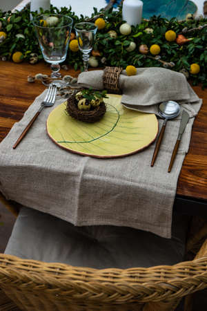Festive table setting for Easter holiday dinner decorated with flowers and eggs