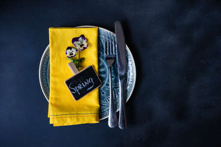 Table setting for holiday easter dinner decorated with spring viola flowers