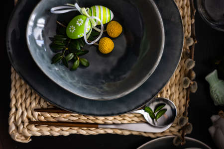 Festive table setting for Easter holiday dinner decorated with flowers and eggs