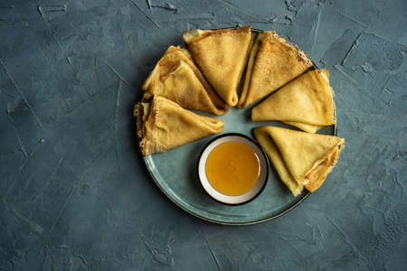 Dessert concept pancakes and honey on ceramic plate with copy space