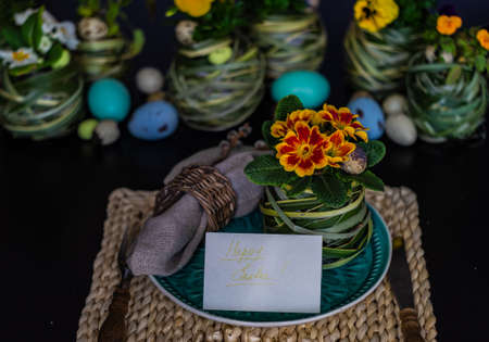 Festive table setting for Easter holiday dinner decorated with flowers and eggs
