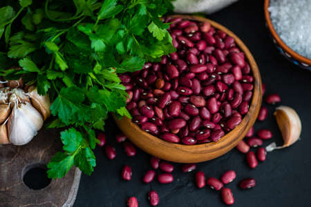 Cooking concept with organic beans in a bowl and ingredients for lobio dishの写真素材