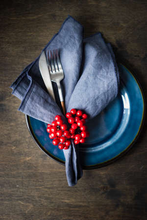 Rustic table setting with ceramic plates and modern cutlery on dark background with copy spaceの写真素材