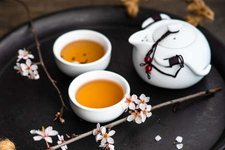 Asian style green tea set and blooming peach tree branch on wooden table with copy spaceの写真素材