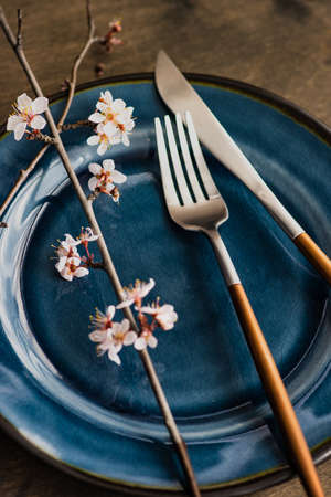 Spring table setting with peach blooming tree branch on wooden background with copy spaceの写真素材