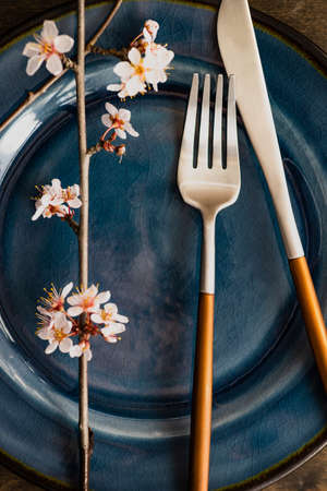 Spring table setting with peach blooming tree branch on wooden background with copy spaceの写真素材