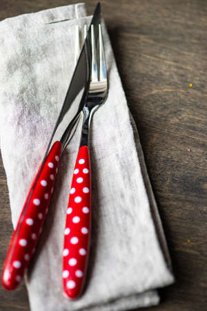 Rustic table setting with ceramic plates and modern cutlery on dark background with copy space