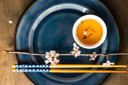 Asian style green tea set and blooming peach tree branch on wooden table with copy spaceの写真素材