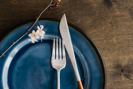 Spring table setting with peach blooming tree branch on wooden background with copy spaceの写真素材