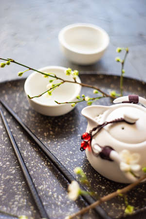 Asian style green tea set and blooming peach tree branch on wooden table with copy spaceの写真素材