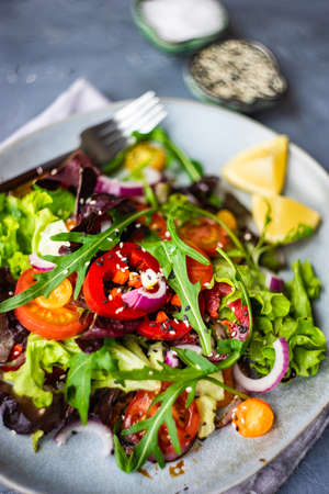 Summer salad with organic vegetables like a tomatoes, pepper, rocket and cucumber