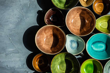 Collecton of empry ceramic bowls on rustic background in sunny day with shadows