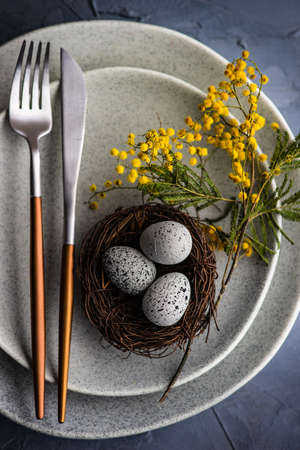 Festive table setting with mimosa flowers for easter holiday dinner