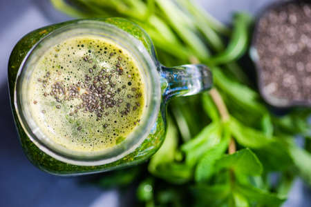 Organic vegetable smoothie with spinach and chia seeds on rustic background with copy space