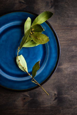Rustic table setting with bay laurel leaves on wooden table with copy spaceの写真素材
