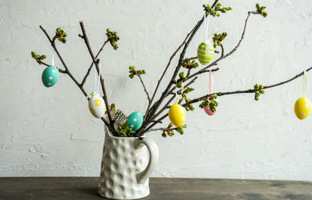 Easter holiday card concept with tree branches and colored eggsの写真素材