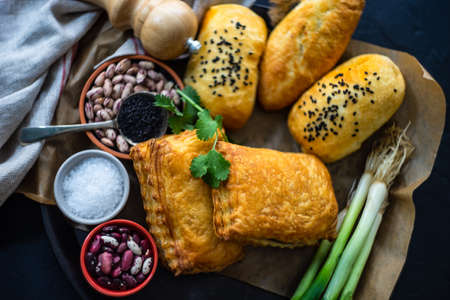 Traditional georgian pies with beans, chicken and eggs with green onion on dark wooden backgroundの写真素材