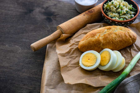 Traditional georgian pies with eggs, rice and green onion on dark wooden backgroundの写真素材