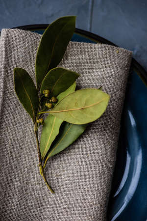 Rustic table setting with bay laurel leaves on wooden table with copy spaceの写真素材