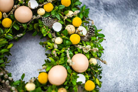 Easter card concept with floral composition with boxwood and colored eggsの写真素材