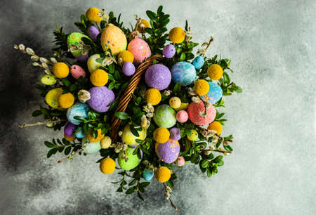 Easter card concept with floral composition with boxwood and colored eggsの写真素材