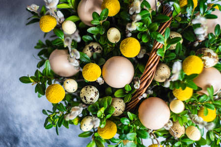 Easter card concept with floral composition with boxwood and colored eggsの写真素材