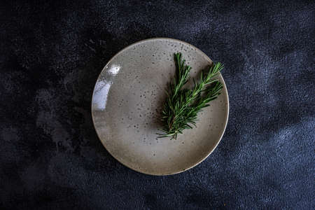 Table setting with fresh rosemary on dark stone table with copy spaceの写真素材