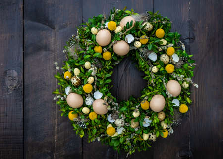 Easter card concept with floral composition with boxwood and colored eggs
