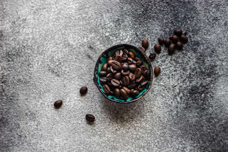 Coffee time concept with  beans in ceramic bowl on concrete background with copy space