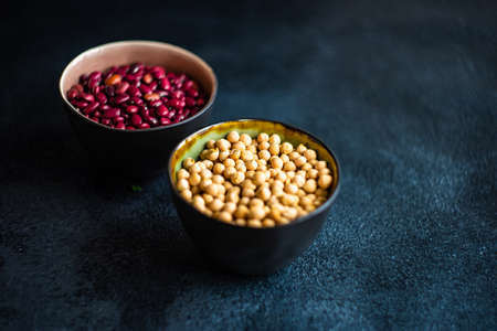 Organic food concept with ceramic bowls with red beans and chick peasの写真素材