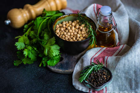 Organic food concept with  raw chick peas, coriander and oil on wooden backgroundの写真素材