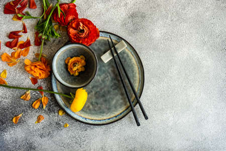 Rustic table setting with ranunculus flowers on concrete background with copy space