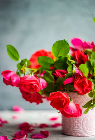Red tea roses bouquet in ceramic vase on the concrete table as a interior decor concept with copy spaceの写真素材