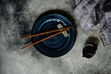 Asian table setting with chopsticks on stone  background with copy space