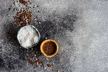 Organic food concept with flax seeds  and  sea salt on grey concrete  backgroundの写真素材