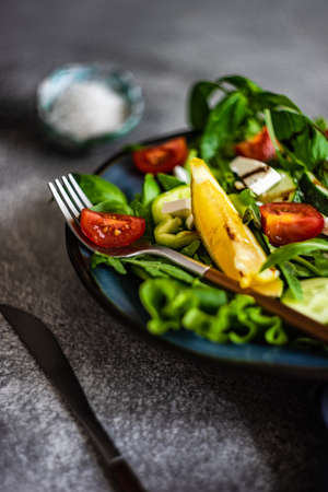 Eat green concept with organic fresh vegetable salad in ceramic bowl on concrete background with copy spaceの写真素材