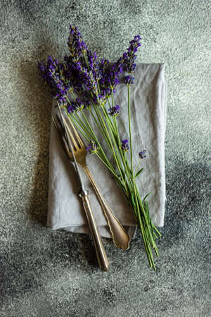 Summer table setting with fresh lavender flowers on concrete background with copy space