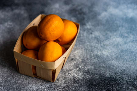Organic food concept with box full of georgian lemons on rusty stone background