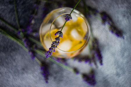 Fresh summer detox drink with lemon and lavender flower on rustic background with copy space