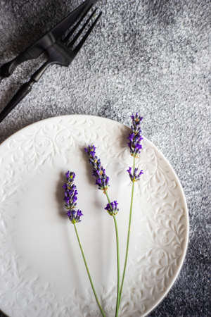 Summer table setting with fresh lavender flowers on concrete background with copy space