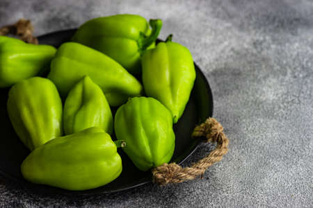 Organic food concept with green bell peppers in a box on rusty backgroundの写真素材