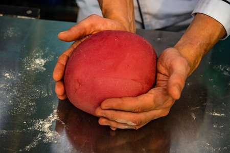 The chef's hand making  dough for traditional italian pasta on a kitchen tableの写真素材