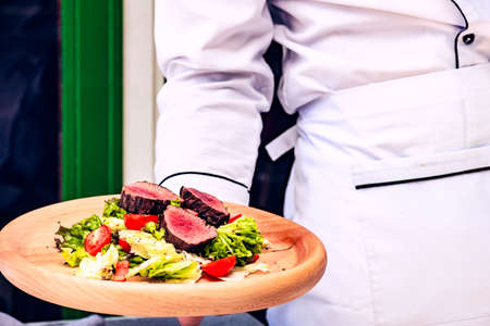 Served steak salad with beef meat and fresh organic lettuce leaves and cherry tomatoes on concrete background with copy spaceの写真素材