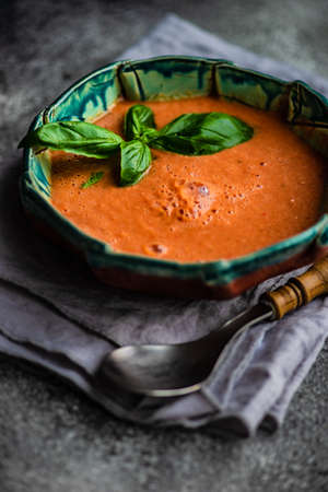 Traditional spanish tomato cream soup Gazpacho in ceramic bowl on rusty stone background with copy spaceの写真素材