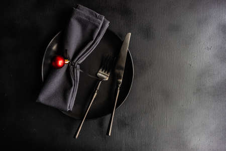 Christmas table setting concept in dark tones with red berries and fir treeの写真素材
