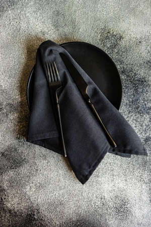 Minimalistic cutlery set in grey and black color with copy space on stone backgroundの写真素材
