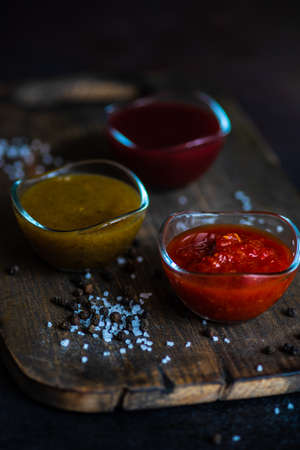 Traditional georgian sauces like tomato satsebeli, yellow and red tkemali with ingredients on stone...