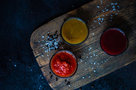 Traditional georgian sauces like tomato satsebeli, yellow and red tkemali with ingredients on stone...