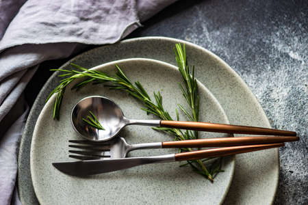 Rusty cutlery set with fresh rosemary herb on stone background with copy spaceの写真素材